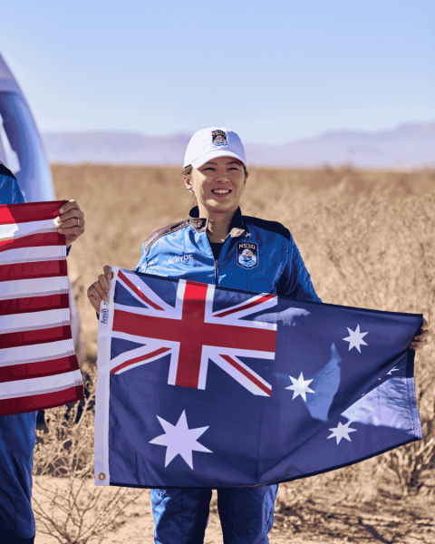 Elaine standing with the Australian flag before the NS-30 mission