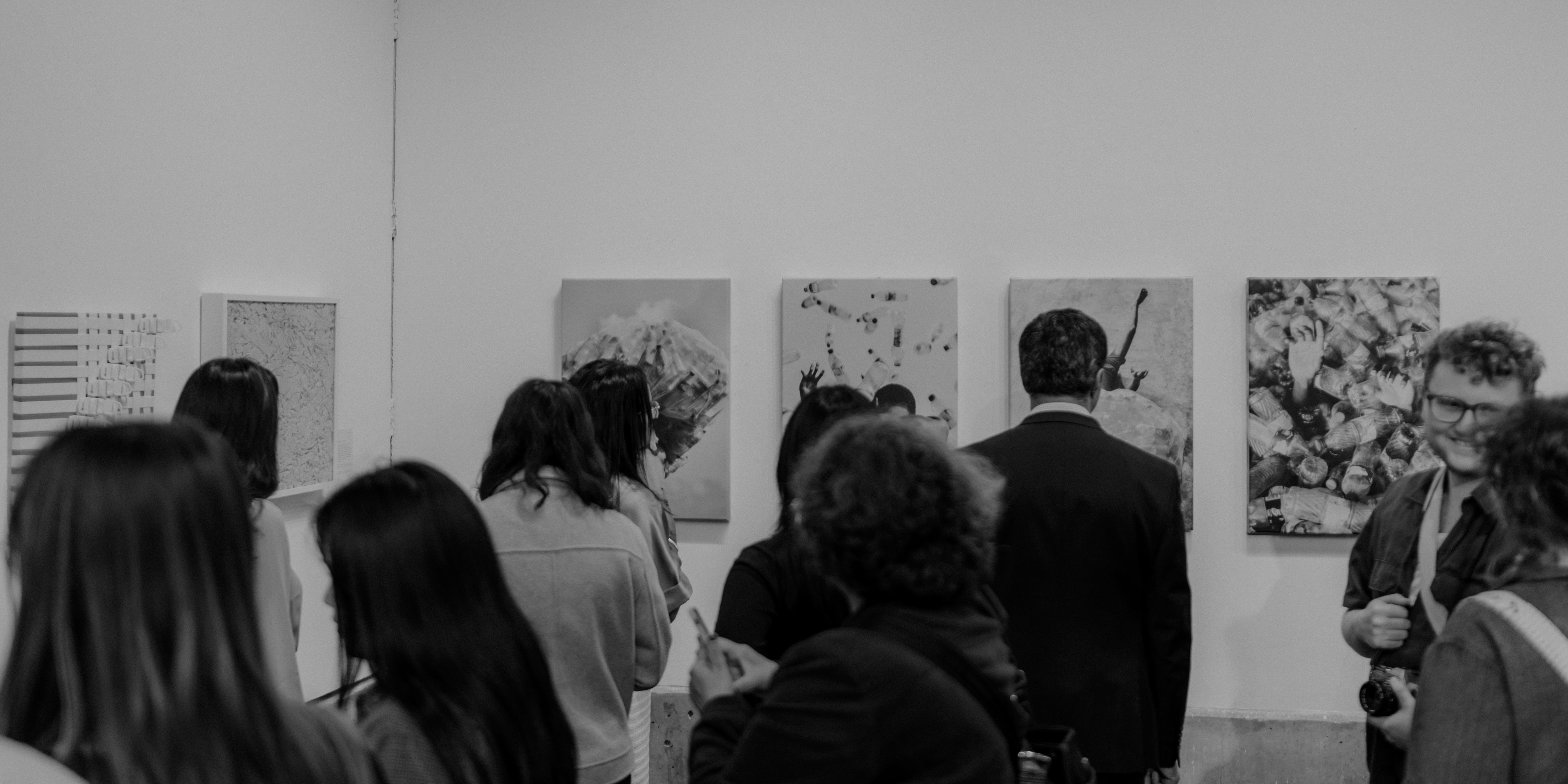 Attendees at the Do No Harm event observing the art, and conversing with each other.