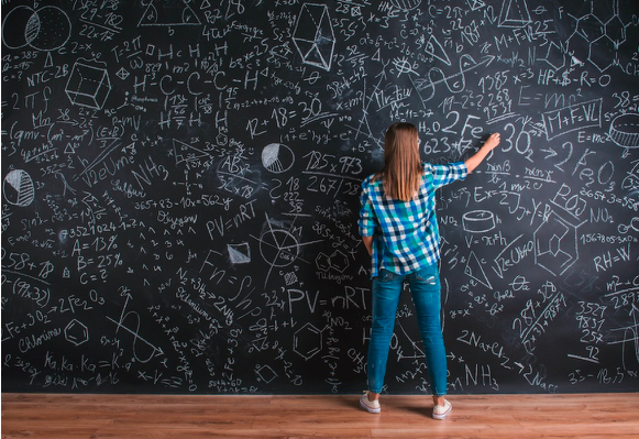 Image of a young girl writing equations on a blackboard.