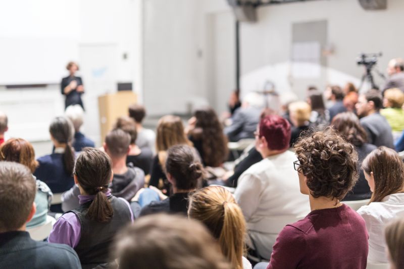 The audience looking toward the front of a presentation