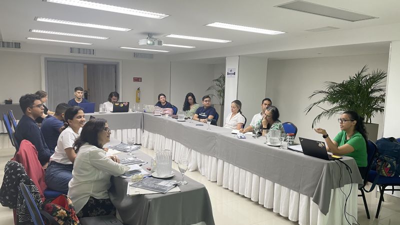 Nuestra Barranquilla A group of people talking while sitting around a u-shaped conference table