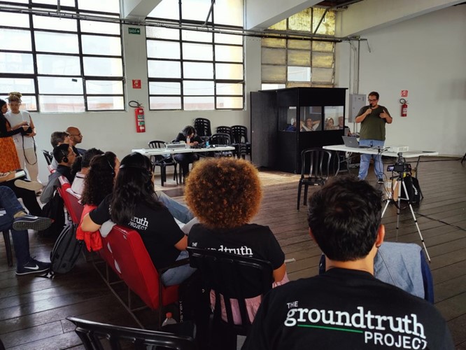 Young journalists listen to a presenter, wearing GroundTruth Project t-shirts