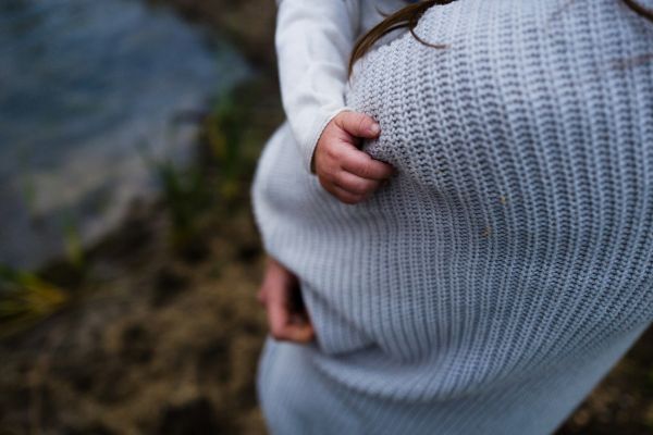 Photo of parent with child cuddling arm. Copyright Jenna Christina.