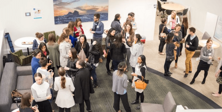 A birds-eye view of a large group of alumni mingling at an event.