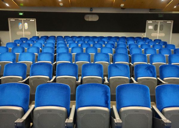 View from front across blue seats in auditorium.