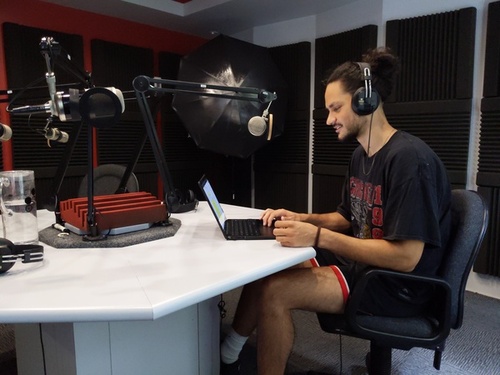 A person wearing headphones and making a recording in a studio. 