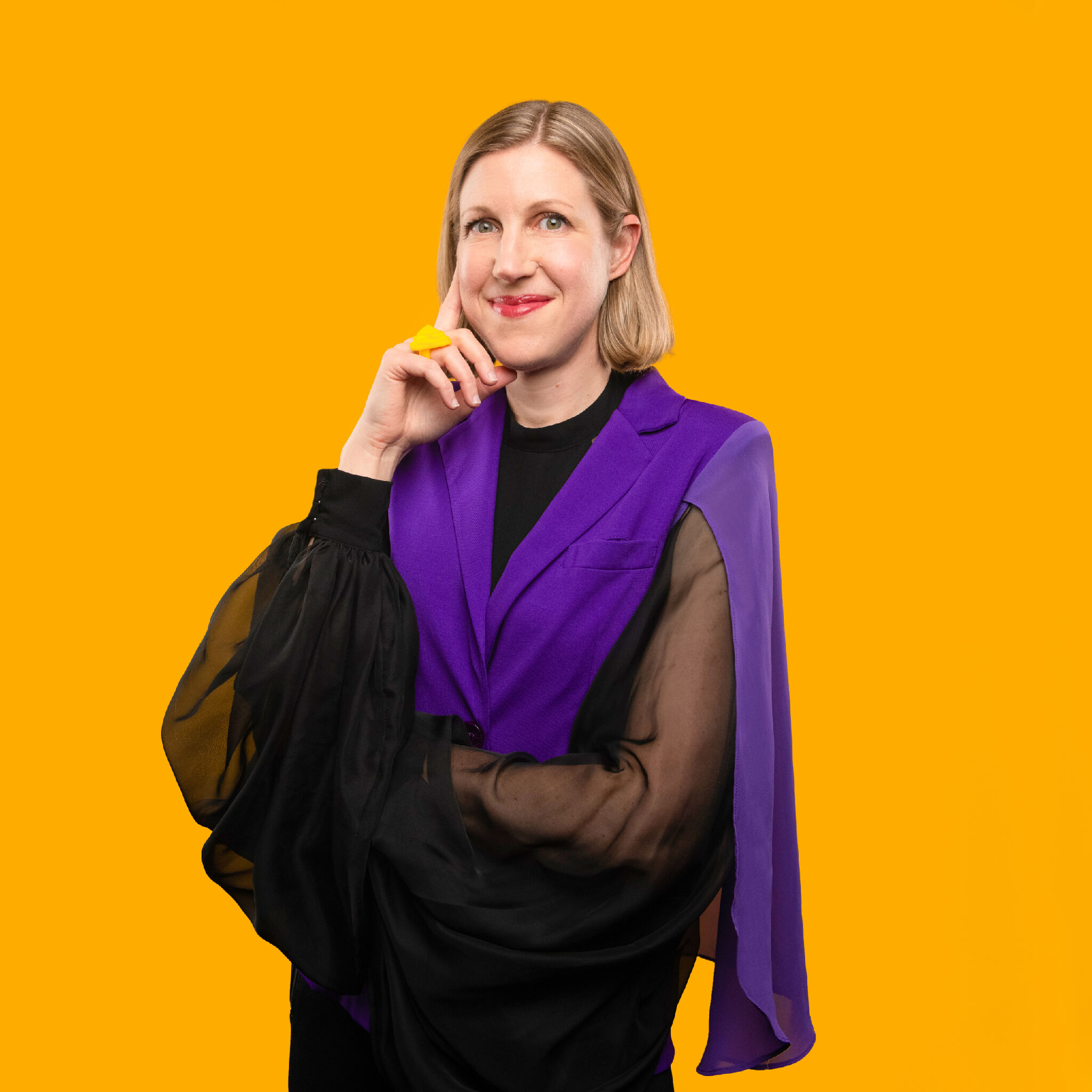 Solange Glasser is standing in front of a yellow background.