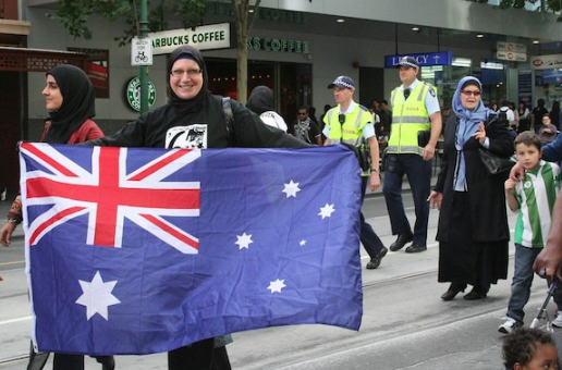 Women wearing hijab smiling with the Australian flag in hand