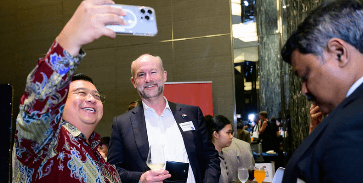 Two alumni at a Singapore Alumni Association event taking a selfie.