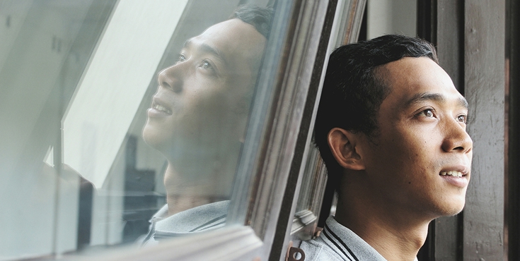 A man gazes thoughtfully out the window.