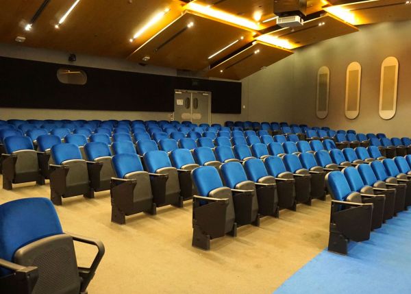 View from front across blue seats in auditorium.