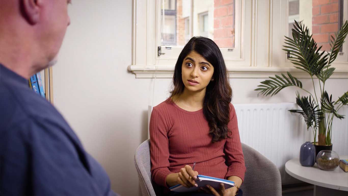 A young woman looks startled at something her client is saying.