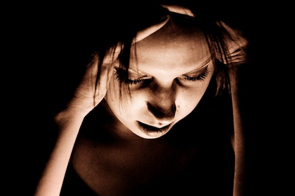 Woman in the dark looking down