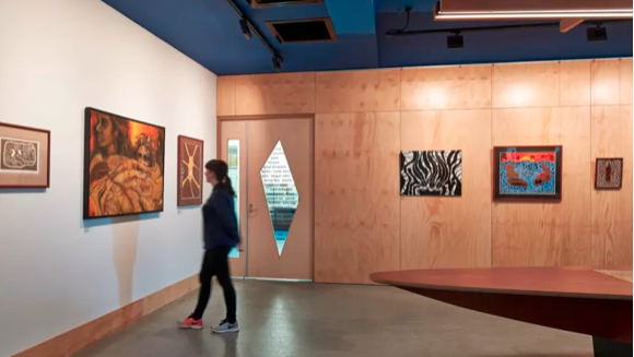 Image of a person observing Indigenous art in a gallery.