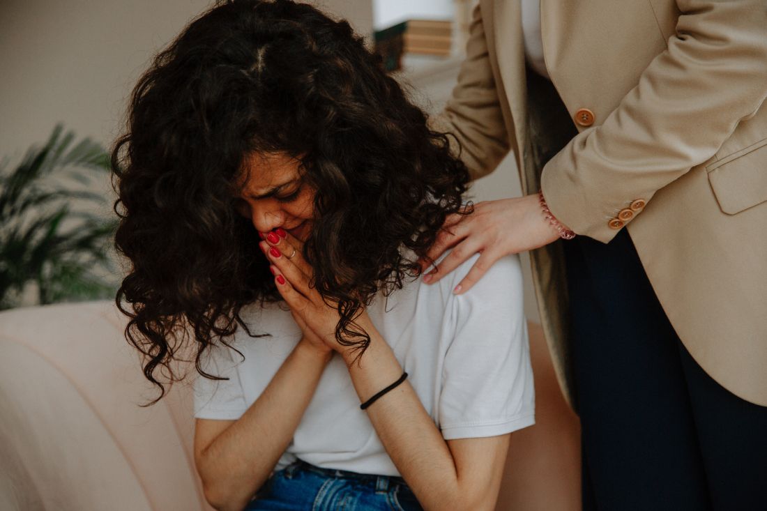 Upset woman being comforted by a health professional