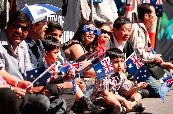 Image of a crowd of women, men and children with Australian flags.