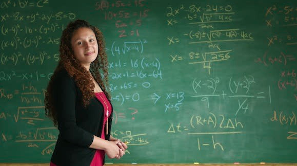 Girl in front of chalkboard in school