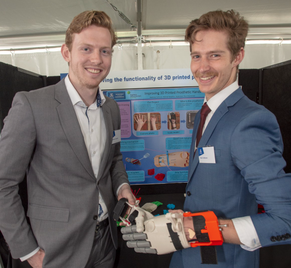 Image of Michael Naughtin and Matt Collinson shaking hands while wearing their prosthetic hands.