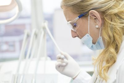 Nurse in medical setting with face mask and pen