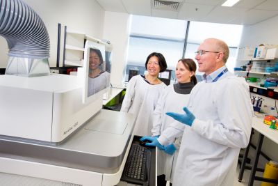 Professor Sean Grimmond and team pictured in the lab with a genome sequencing machine
