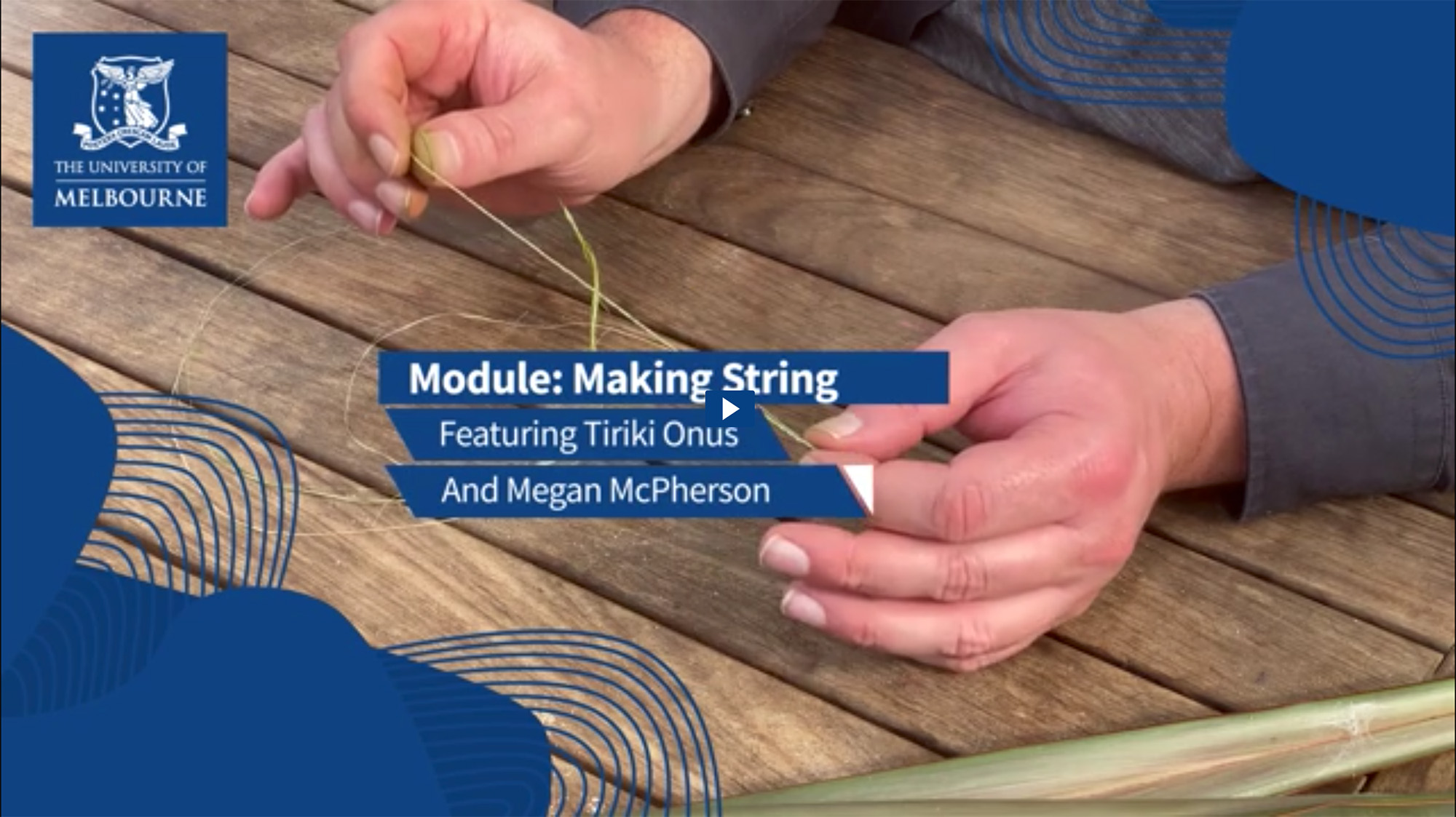 Person seated at a wooden table tying a knot in a piece of string