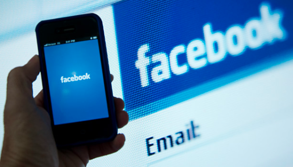 Hand holding phone with Facebook open