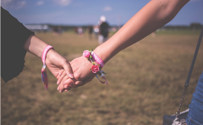 Image of two women holding hands.
