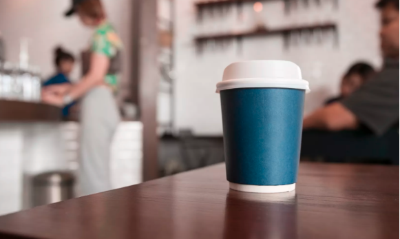 Image of a non-reusable coffee take away cup in a cafe.