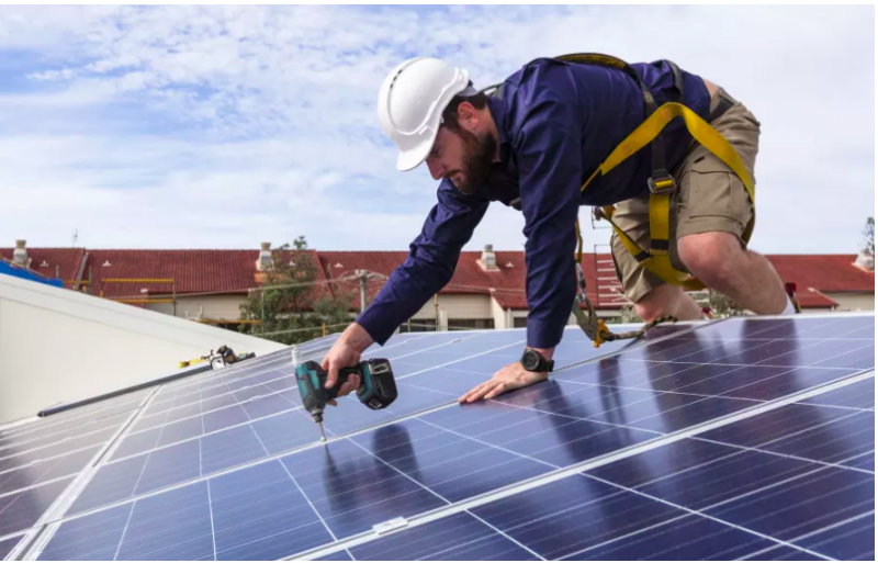 Image of a person installing solar panels. so