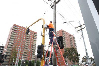 Man installs AIMES sensors at intersection