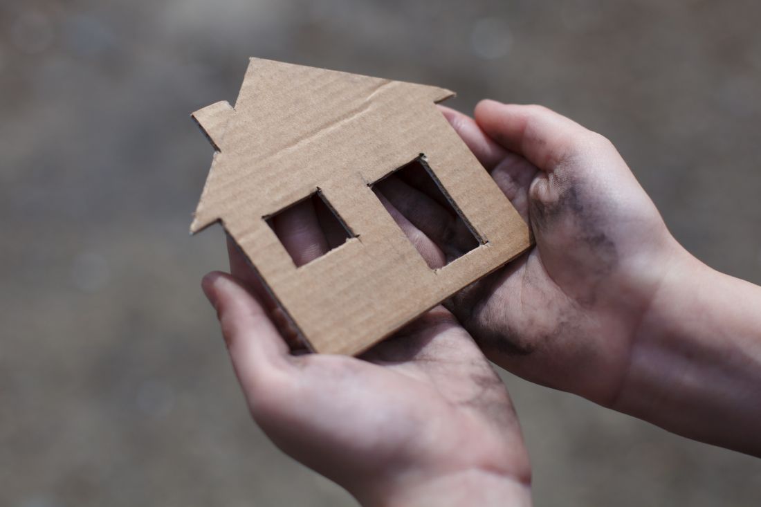 Hands holding cardboard house cut out 