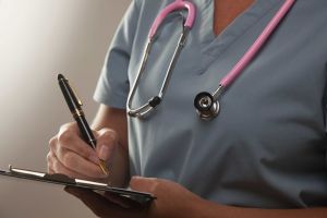 Nurse with stethoscope writing