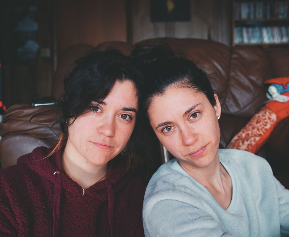 Twin girls sitting next to each other