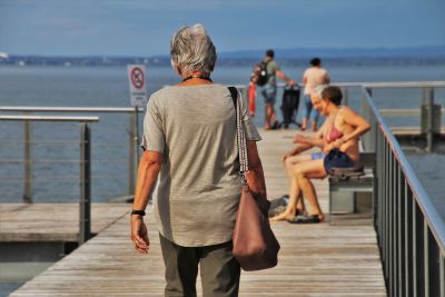 Older woman walking along a pier 