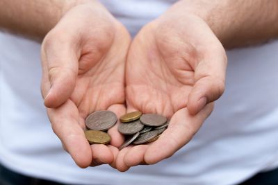 Two hands holding silver money coins 
