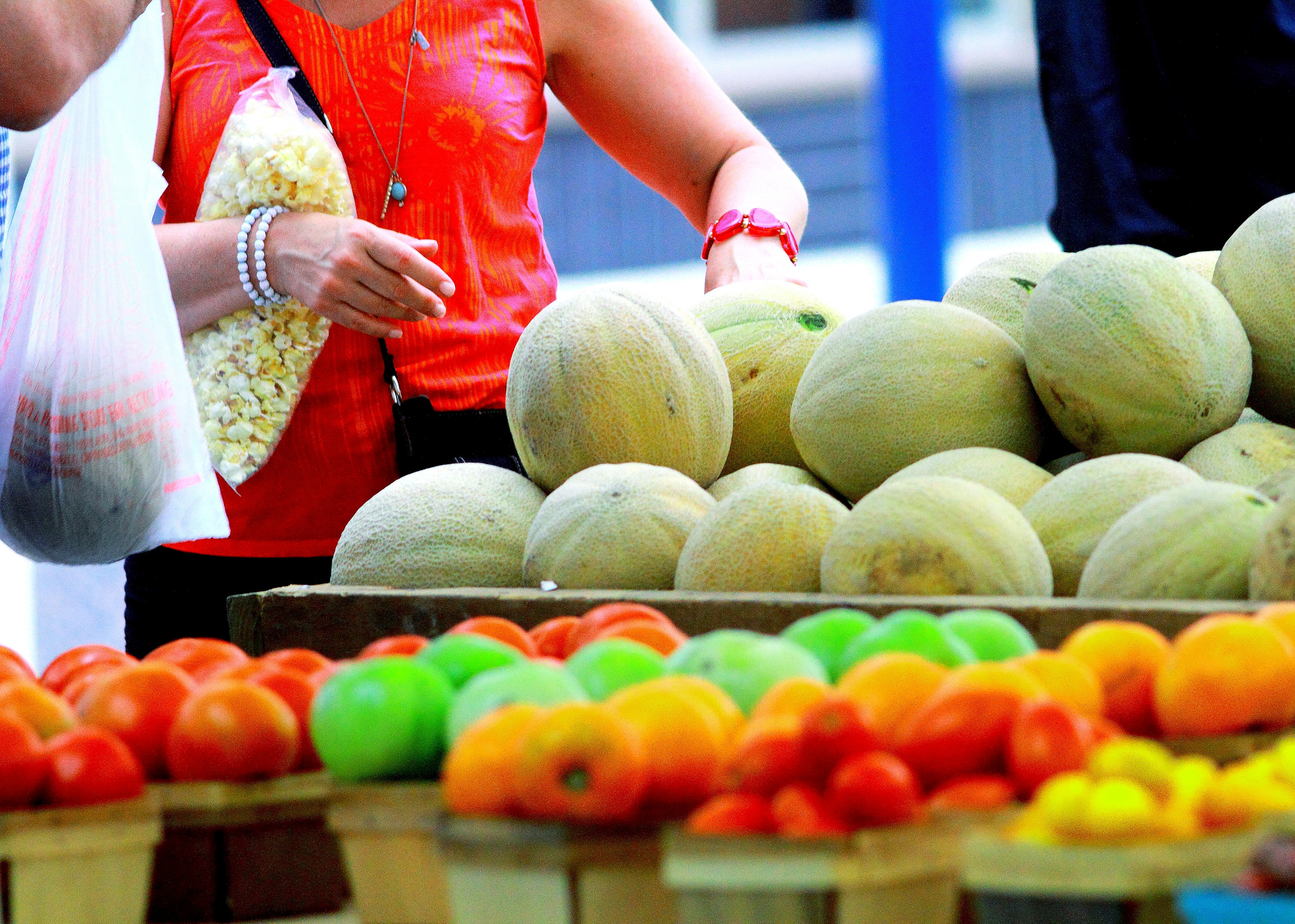 Shoppers handing fruit at a farmers market