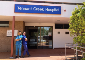 Two medical students standing back-to-back out the front of Tennant Creek hospital