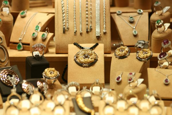 A photo of lots of big gold bling jewels set out as if they are in a jewellery store